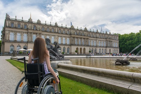 Frau im Rollstuhl vor dem Schloss Herrenchiemsee